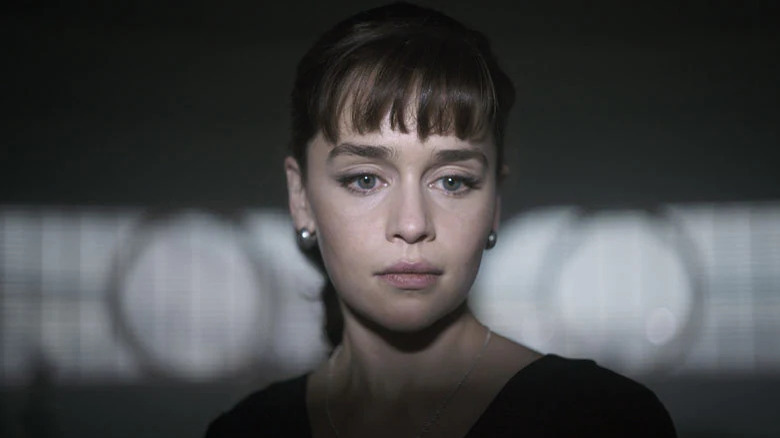 Qi'ra stands in the shadows