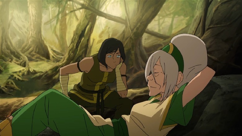 Toph taking a nap while Korra watches
