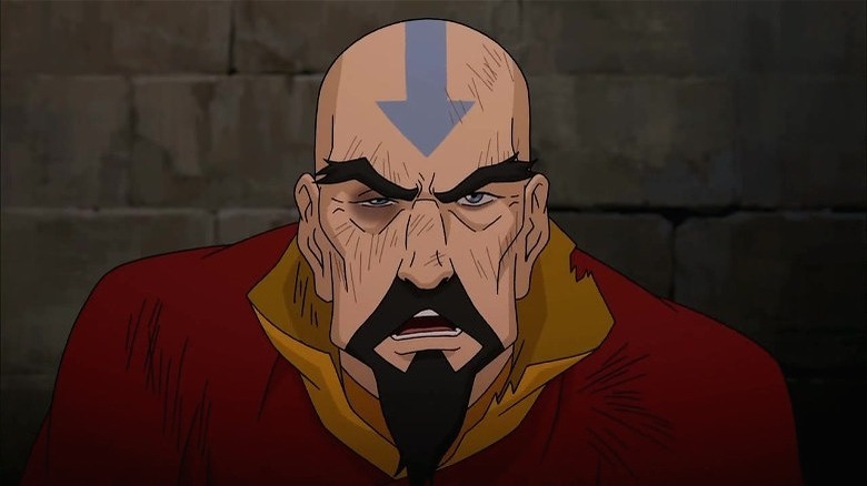 A battered Tenzin speaking with brows furrowed