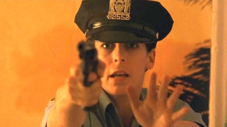 Jamie Lee Curtis as Officer Megan Turner pointing a gun and holding up the palm of her hand in Blue Steel