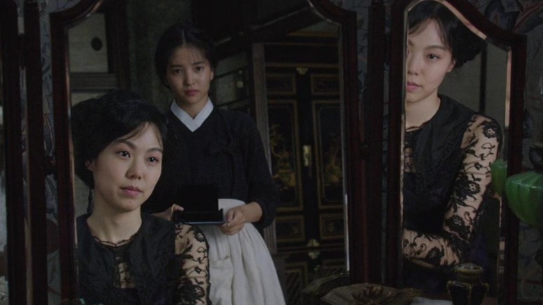 Kim Min-hee as Lady Hideko and Kim Tae-ri as Sook-hee looking at each other through a mirror in The Handmaiden