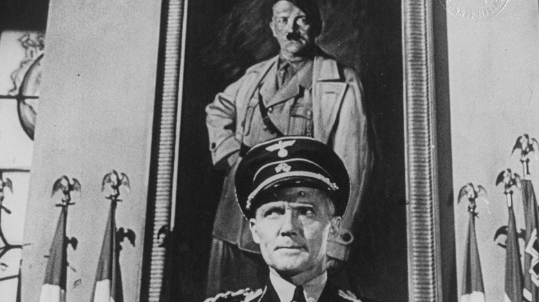 Hans Heinrich von Twardowski as Reinhard Heydrich standing in front of Hitler painting in Hangmen Also Die