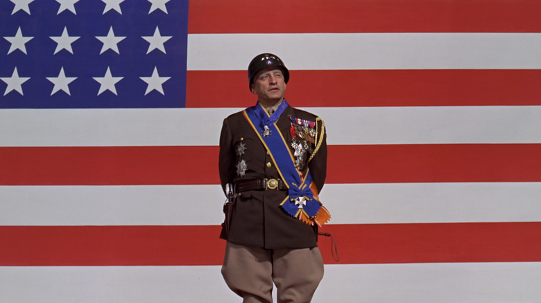 Patton (George C. Scott) speaking in front of a giant American flag in Patton