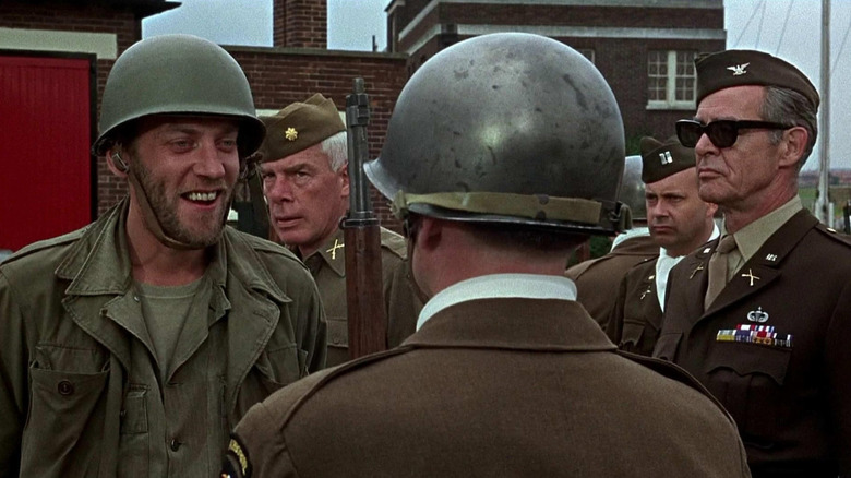 Vernon (Donald Sutherland) smirks at a soldier while Major John Reisman (Lee Marvin) and Col. Everett Dasher Breed (Robert Ryan) look on in The Dirty Dozen