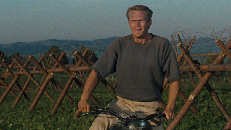 Hilts (Steve McQueen) on a motorcycle outside a prison fence in The Great Escape