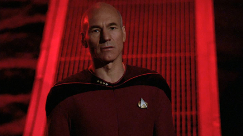 Picard (Patrick Stewart) stands in a red-lit room in Star Trek: The Next Generation