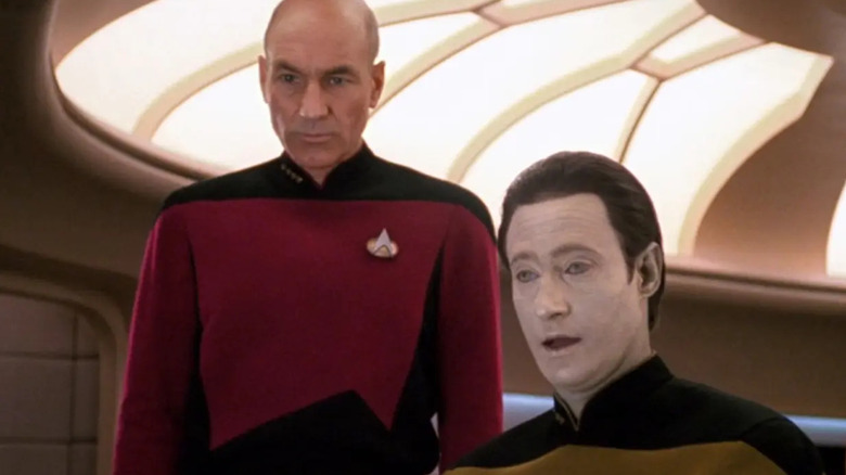 Picard (Patrick Stewart) stands solemnly behind Data (Brent Spiner) in Star Trek: The Next Generation