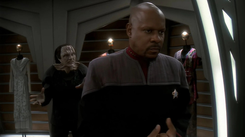 Garak (Andrew Robinson) speaks behind a contemplative Sisko (Avery Brooks) in Star Trek: Deep Space Nine