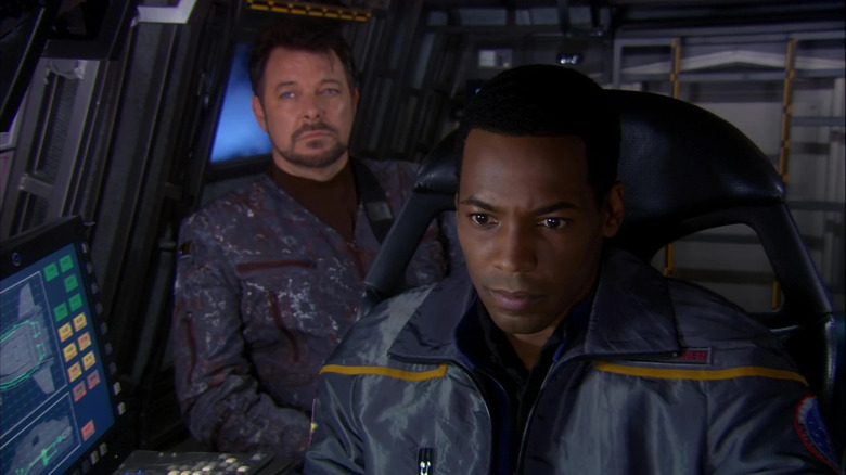 Riker (Jonathan Frakes) sits behind Travis Mayweather (Anthony Montgomery) in Star Trek: Enterprise