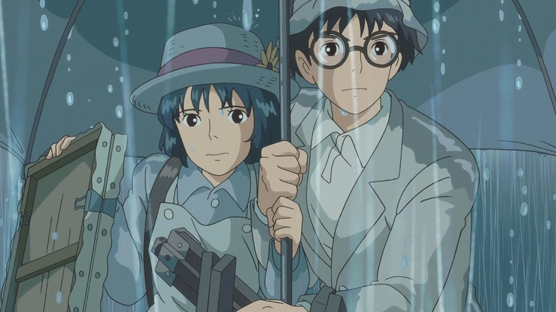 Jiro Horikoshi holds an umbrella for Nahoko as she carries a canvas in the rain in The Wind Rises