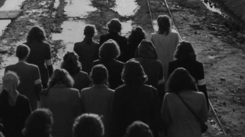 Women walking through a muddy path in Auschwitz in The Last Stage