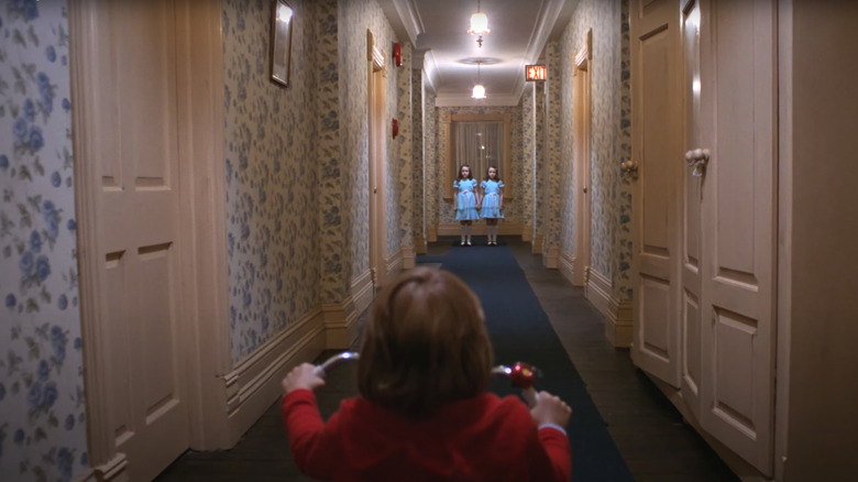 Two ghostly girls at the end of a hallway in Stanley Kubrick's "The Shining"