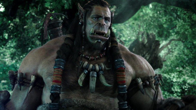 Durotan, voiced by Toby Kebbell, stands in a forest in Warcraft