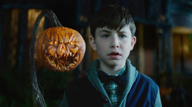 the house with a clock in its walls boy next to evil pumpkin