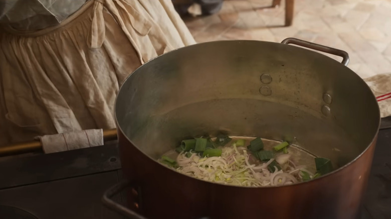 Bowl of ingredients on stovetop in The Taste of Things