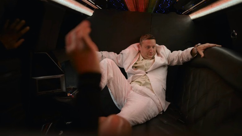 Tim Robinson laying in limo seat