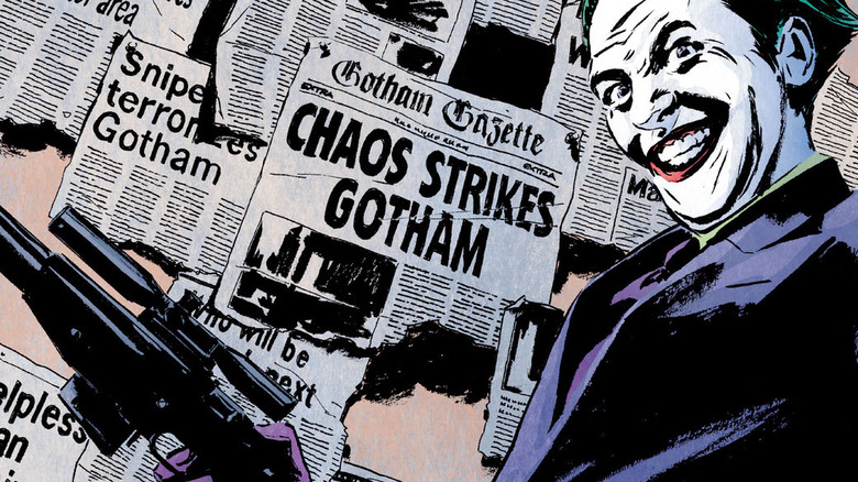 Joker poses in front of newspapers