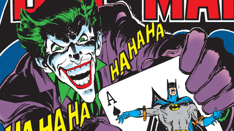 The Joker straps Batman to a playing card