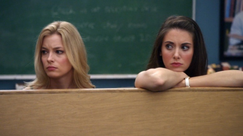 Annie and Britta stand behind table