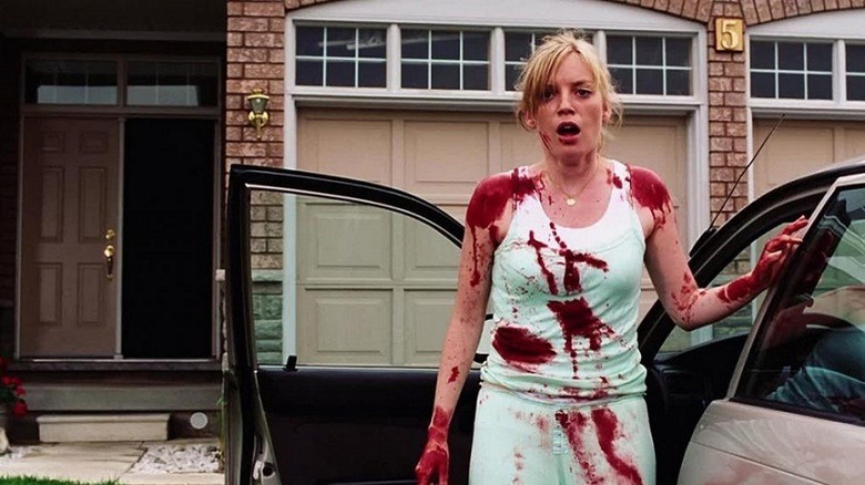 Ana, covered in blood, standing by her car