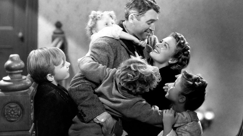 James Stewart as George Baily being hugged by his wife and children in It's A Wonderful Life.