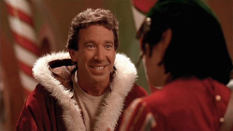 Tim Allen as Scott Calvin/Santa Claus smiling at a young boy while wearing a Santa suit in The Santa Clause.