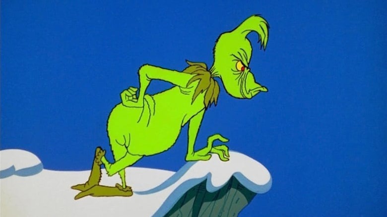 The Grinch looking down over a snowy cliff in How the Grinch Stole Christmas.