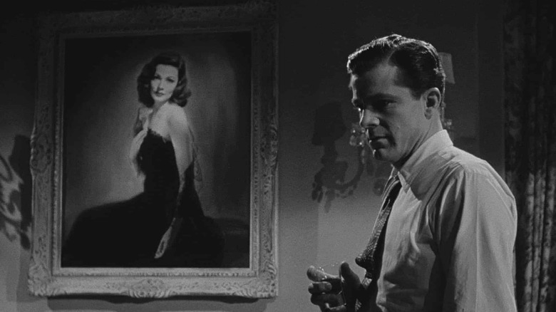 Detective Mark McPherson stands in front of Laura's portrait in Laura (1944)