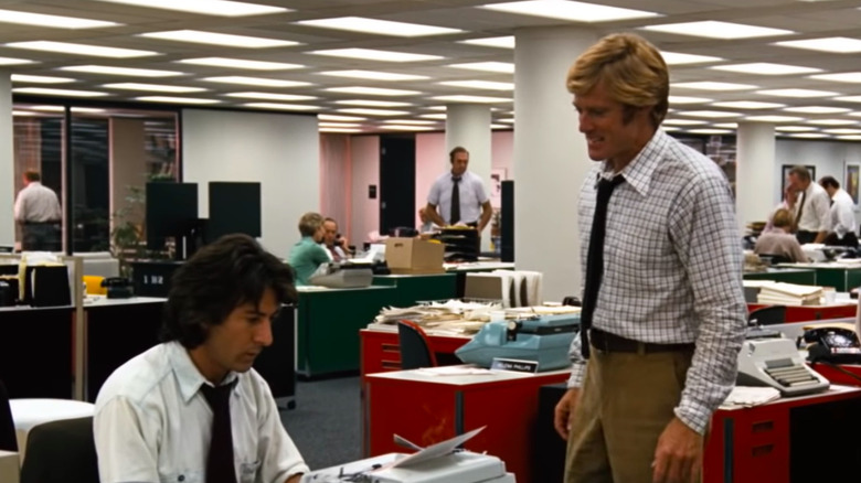 Dustin Hoffman typing and Robert Redford standing