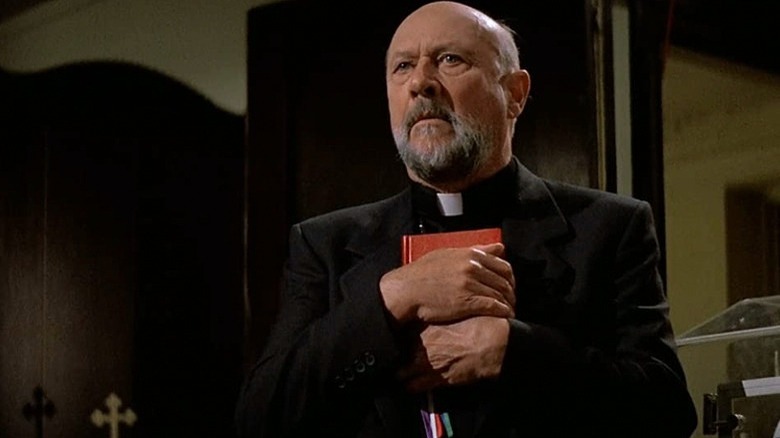 Donald Pleasence clutching bible