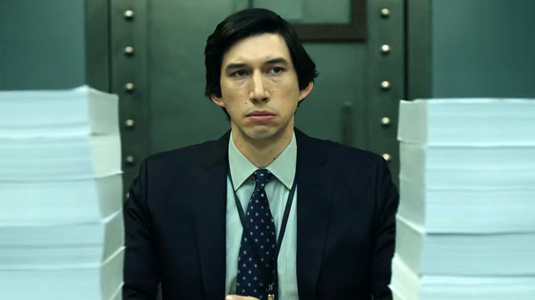 Adam Driver sitting at desk