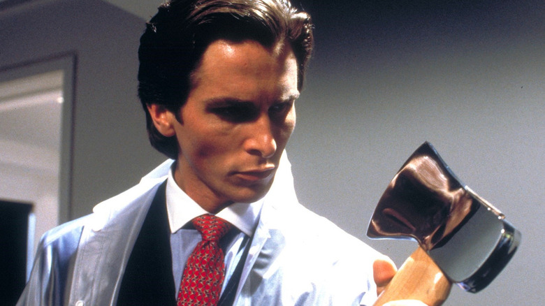 Patrick Bateman wears suit and holds axe