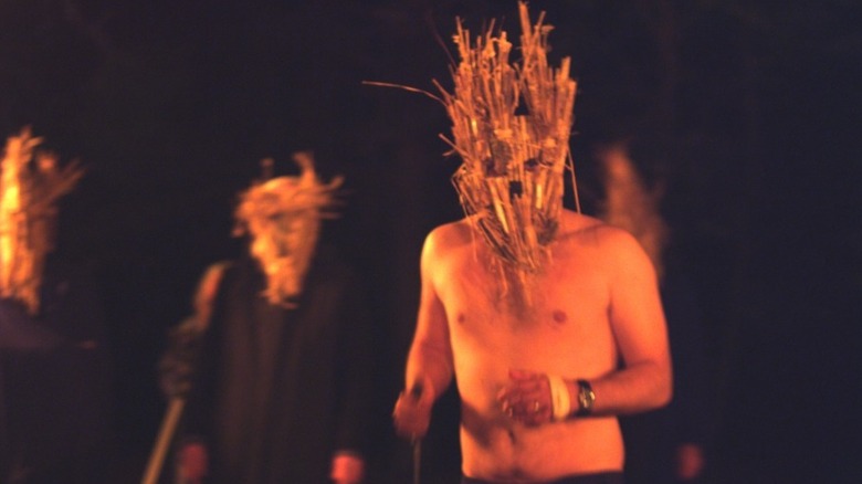 men in straw demon masks