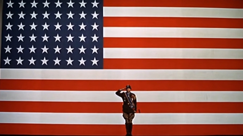 Patton saluting in front of flag