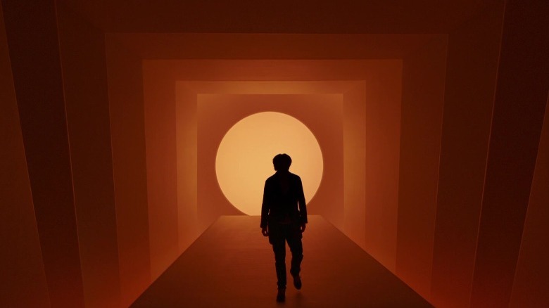 Silhouetted man in an orange hallway