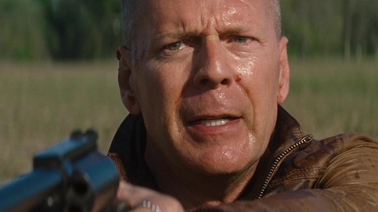 Bruce Willis as Old Joe who looks sweaty and holds a gun in Looper