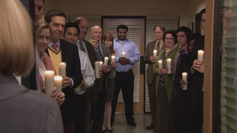 Dunder Mifflin employees holding candles in The Office