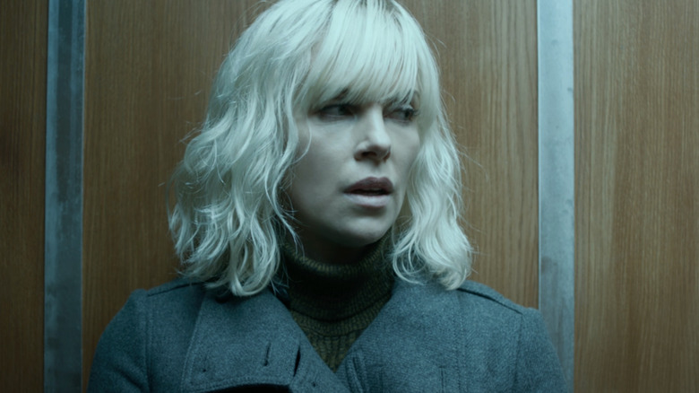 Charlize Theron as Lorraine Broughton waits aboard an elevator.