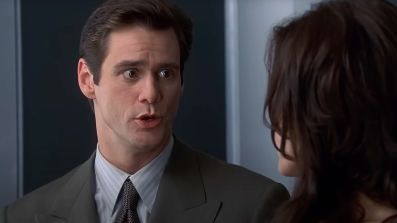 Jim Carrey as Fletcher Reed makes faces at a woman in an elevator in Liar Liar