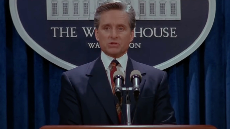 Michael Douglass as President Shepherd in front of the White House seal.