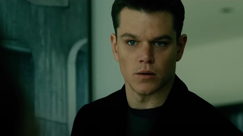 Matt Damon as Jason Bourne looks concerned in a room.