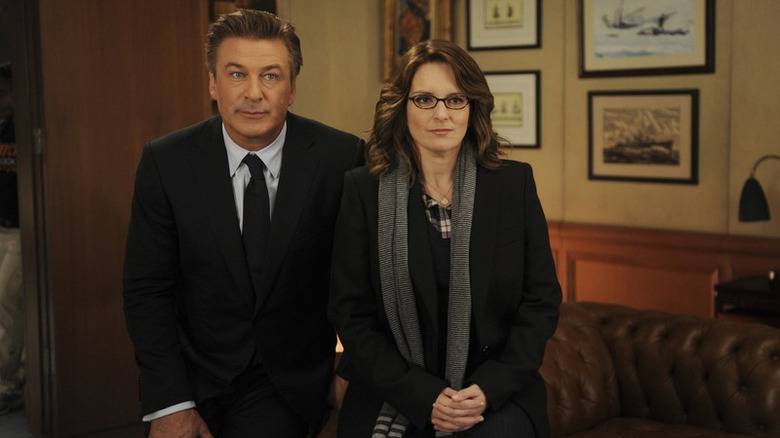 Liz (Tina Fey) stands next to Jack (Alec Baldwin) in his office on 30 Rock