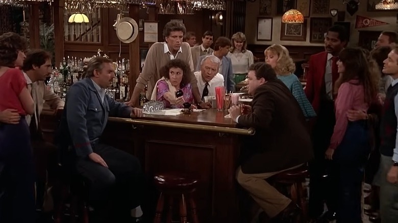 The employees and patrons of Cheers gathered around the bar counter