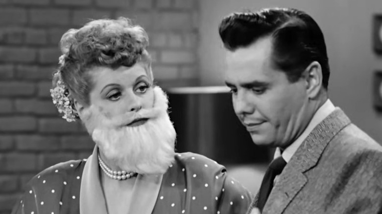 I Love Lucy's Lucy wearing an enormous white fake beard while Ricky looks away