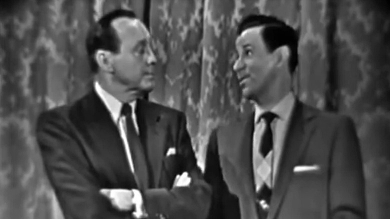 The Jack Benny Program's Jack with arms crossed hearing Dennis speak