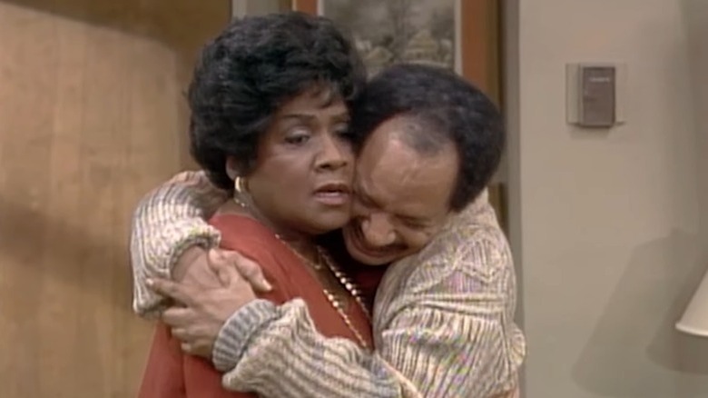 The Jeffersons' George Jefferson gleefully embracing an annoyed Louise