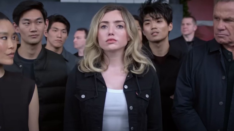 Peyton List as Tory Nichols standing with Cobra Kai dojo members