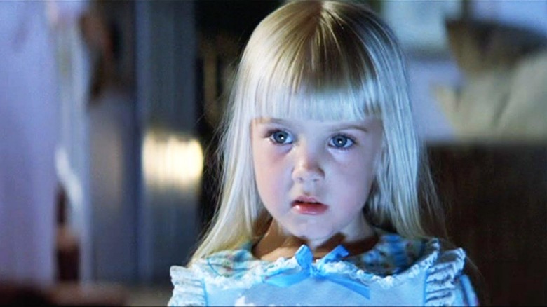 Heather O'Rourke as Carol Anne staring at the glowing TV in Poltergeist