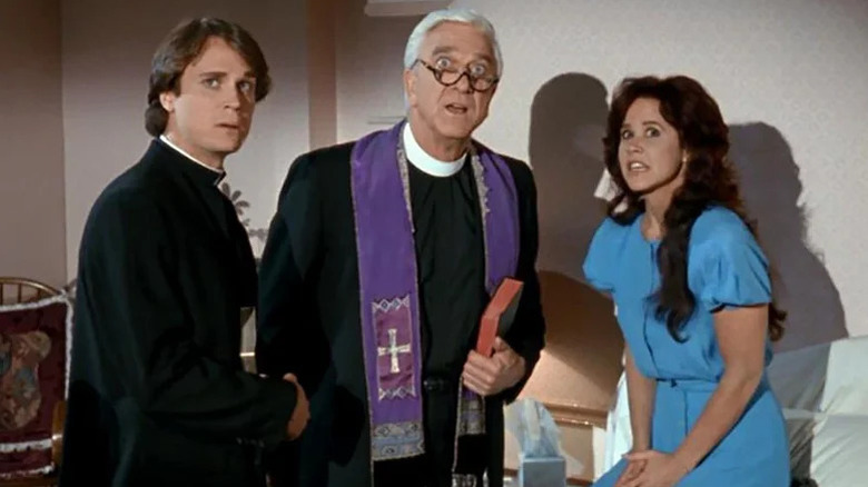 Father Brophy (Anthony Starke), Father Mayii (Leslie Nielsen), and Nancy Aglet (Linda Blair) looking scared in Repossessed