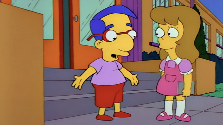 Milhouse stands next to his girlfriend outside school in The Simpsons